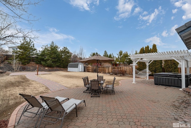 view of patio with a storage shed, outdoor dining space, fence, a pergola, and an outdoor structure