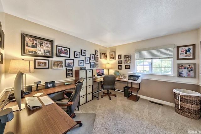 carpeted office space featuring a textured ceiling, visible vents, and baseboards