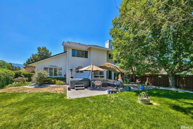 rear view of property with fence, an outdoor living space, a yard, a patio area, and a hot tub