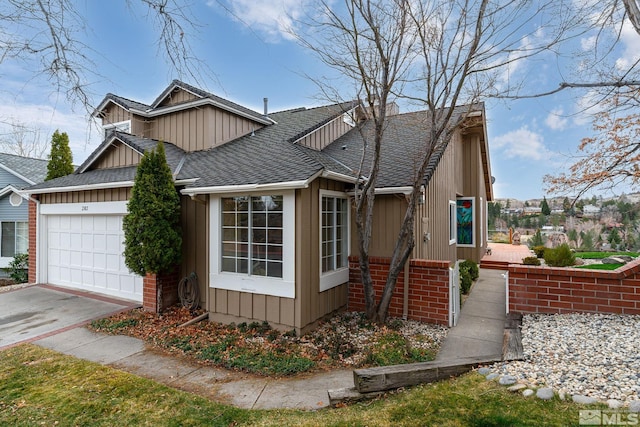 view of front of property featuring a garage, board and batten siding, roof with shingles, and concrete driveway