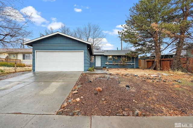 ranch-style house with a garage, roof mounted solar panels, driveway, and fence