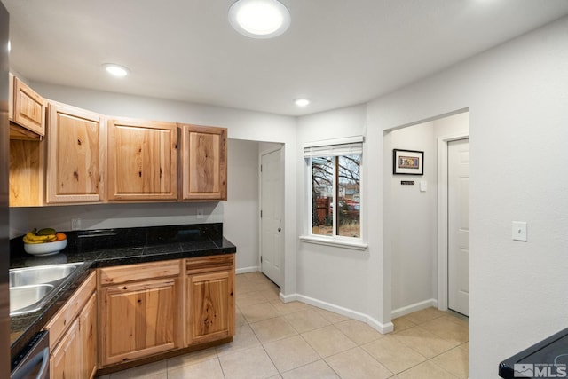 kitchen with tile countertops, light tile patterned floors, stainless steel dishwasher, a sink, and baseboards