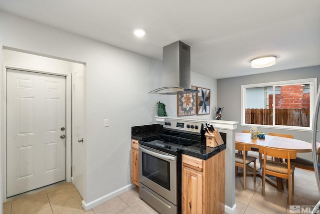 kitchen with light tile patterned floors, baseboards, island range hood, and stainless steel range with electric cooktop