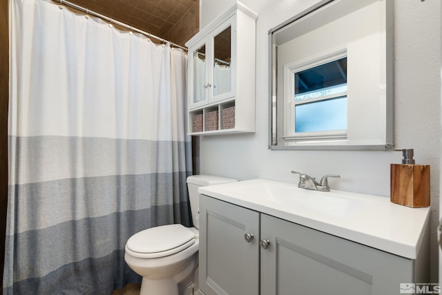 bathroom featuring curtained shower, vanity, and toilet