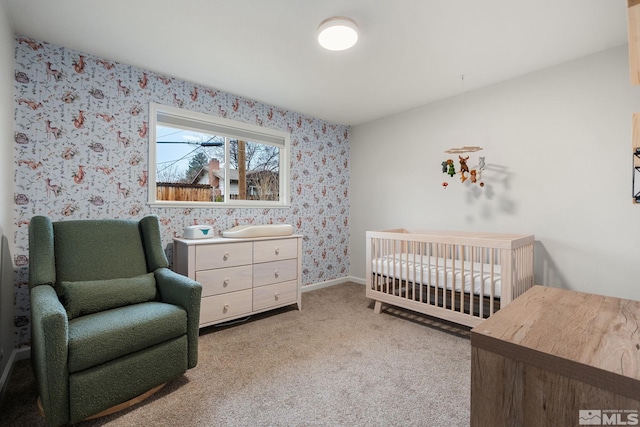 bedroom with carpet, baseboards, a nursery area, and wallpapered walls