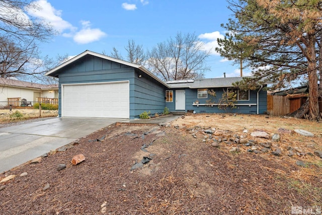 ranch-style house featuring driveway, board and batten siding, an attached garage, and fence