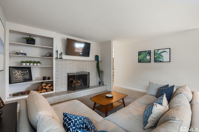 carpeted living room featuring built in shelves, a fireplace, and baseboards