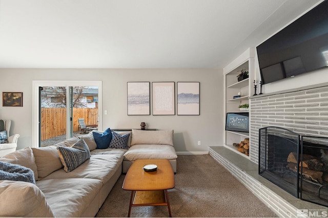 carpeted living room with built in shelves, a brick fireplace, and baseboards