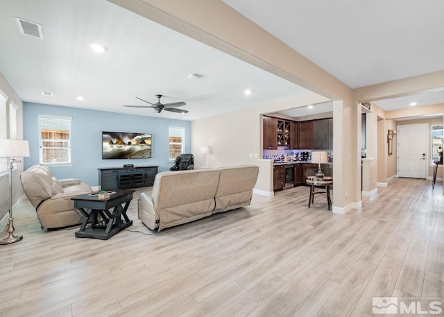 living room featuring light wood-type flooring, baseboards, visible vents, and recessed lighting