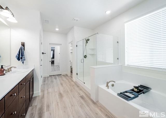 full bathroom with a garden tub, visible vents, a stall shower, vanity, and wood finished floors