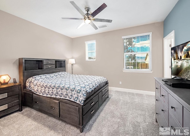 bedroom featuring baseboards, visible vents, a ceiling fan, and light colored carpet