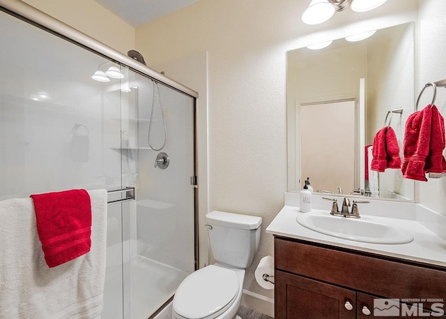 full bath featuring a stall shower, vanity, and toilet