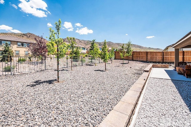 view of yard with a patio, fence, and a mountain view