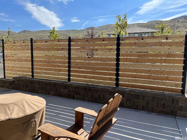 view of patio / terrace with fence and a mountain view