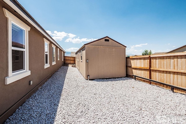 view of yard with an outbuilding, a fenced backyard, and a shed