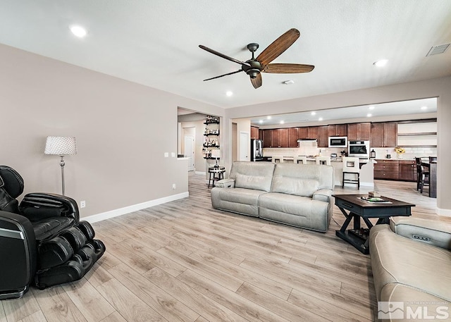 living room with recessed lighting, visible vents, baseboards, a ceiling fan, and light wood finished floors