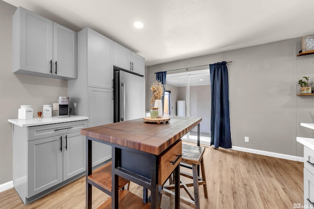 kitchen with baseboards, gray cabinets, and light wood-style floors