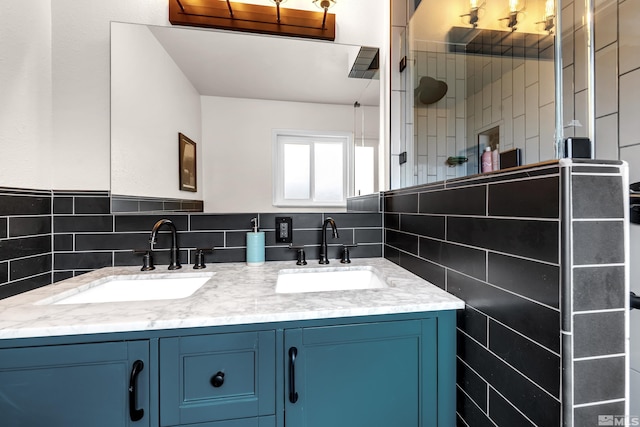 bathroom with tiled shower, a sink, tile walls, and double vanity