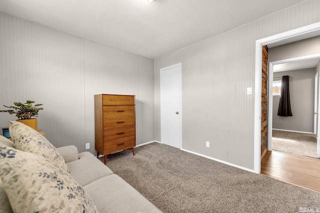 living area with carpet flooring, wood finished floors, and baseboards