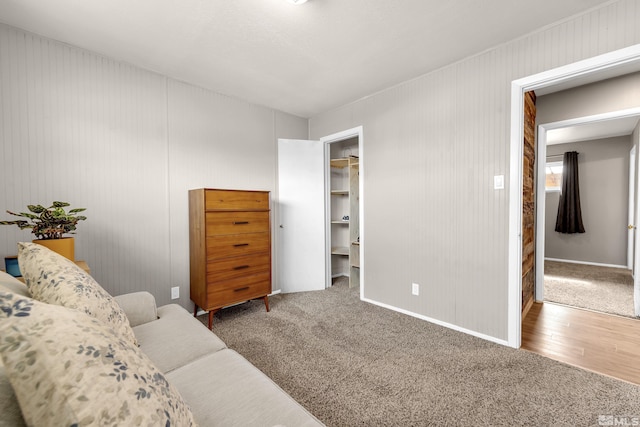 interior space with carpet, baseboards, and wood finished floors