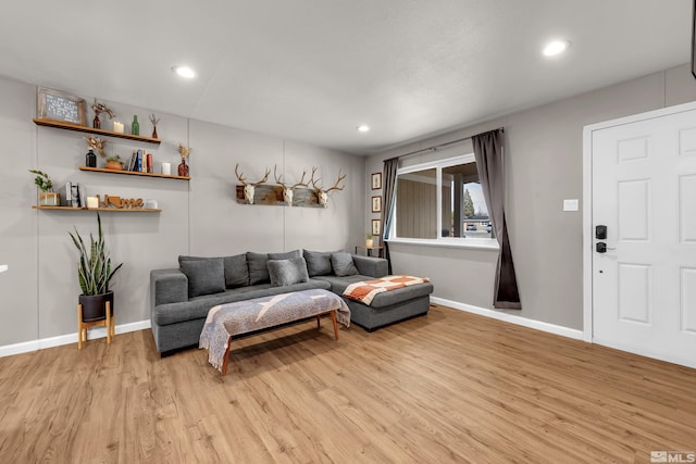 living area with baseboards, light wood-style flooring, and recessed lighting