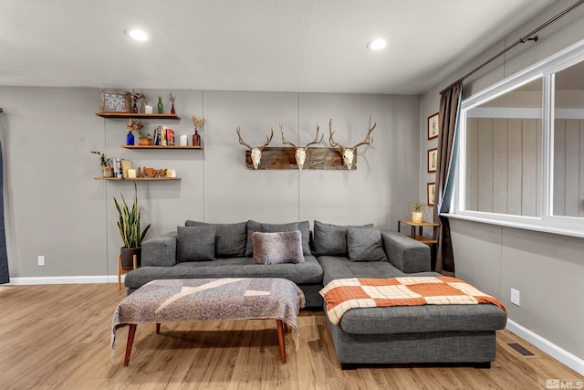 living area with baseboards, visible vents, wood finished floors, and recessed lighting