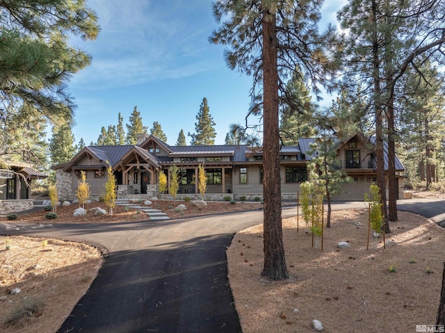 view of front of home featuring aphalt driveway, metal roof, and an attached garage