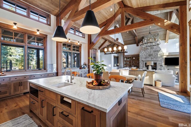 kitchen featuring wooden ceiling, wood-type flooring, stainless steel microwave, and a sink