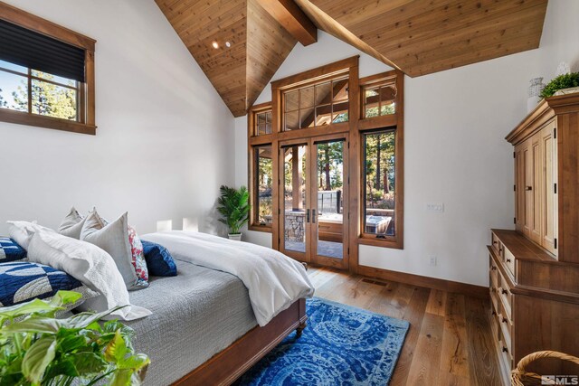 bedroom with access to exterior, baseboards, multiple windows, and hardwood / wood-style floors