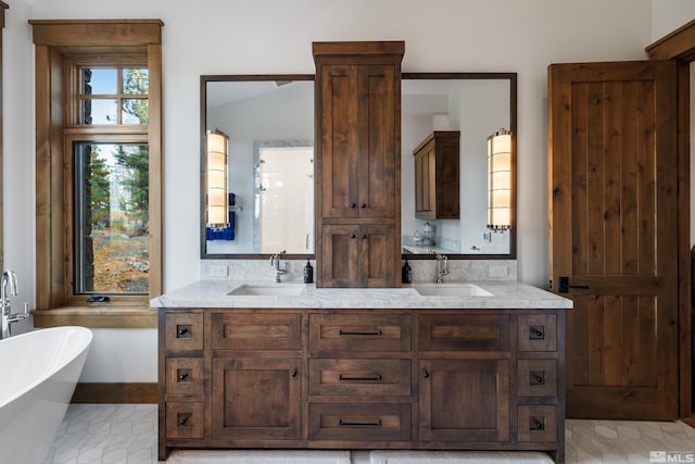 full bath with double vanity, a soaking tub, and a sink