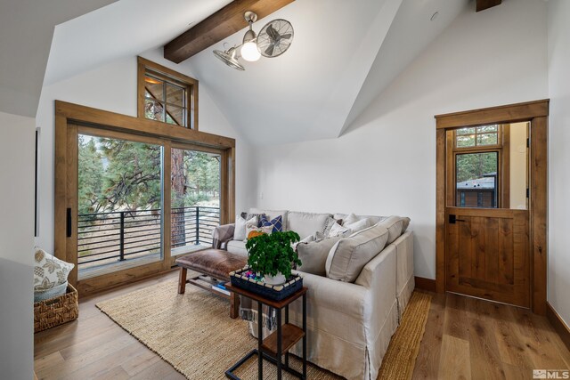 living area featuring baseboards, beam ceiling, high vaulted ceiling, and wood finished floors