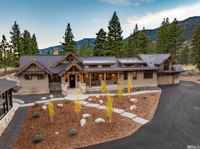 view of front facade featuring a standing seam roof, a chimney, and metal roof