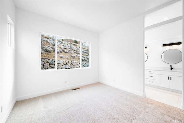 unfurnished bedroom with light colored carpet, visible vents, and baseboards