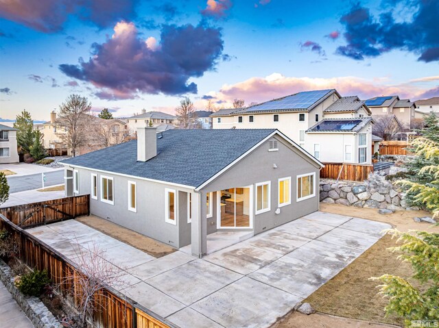 view of front of property with a residential view, a patio area, a fenced backyard, and stucco siding