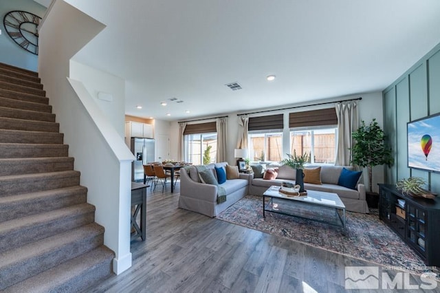 living area with stairs, wood finished floors, visible vents, and recessed lighting