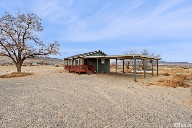 manufactured / mobile home featuring driveway, a mountain view, and a carport