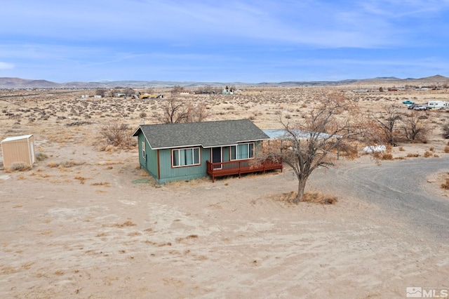 view of front of house with a deck with mountain view and a desert view