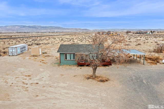 view of front facade featuring a mountain view, a carport, and view of desert