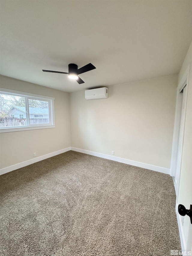 carpeted spare room featuring a ceiling fan, a wall mounted air conditioner, and baseboards