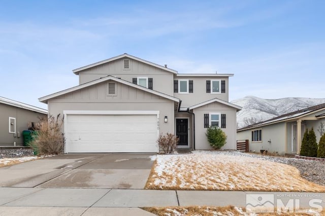 traditional home featuring driveway, an attached garage, a mountain view, and board and batten siding