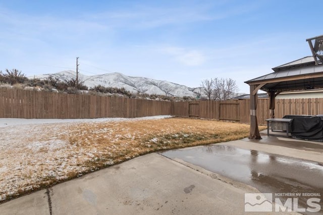 view of yard featuring a gazebo, a fenced backyard, a mountain view, and a patio