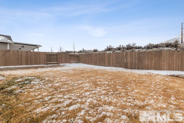 snowy yard featuring fence