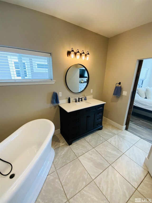 full bath with a freestanding tub, connected bathroom, vanity, and tile patterned floors