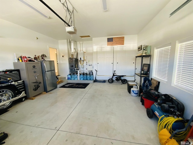 garage with a garage door opener and freestanding refrigerator