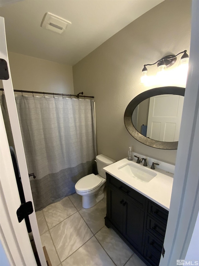 bathroom with toilet, a shower with shower curtain, vanity, and tile patterned floors