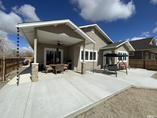 rear view of house featuring ceiling fan, a patio, a fenced backyard, and stucco siding