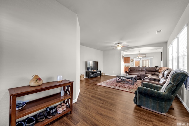 living room with visible vents, baseboards, dark wood-style flooring, and ceiling fan with notable chandelier