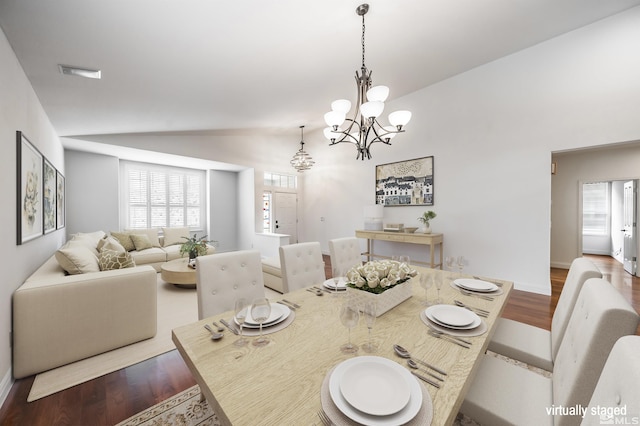 dining area featuring visible vents, vaulted ceiling, wood finished floors, a chandelier, and baseboards