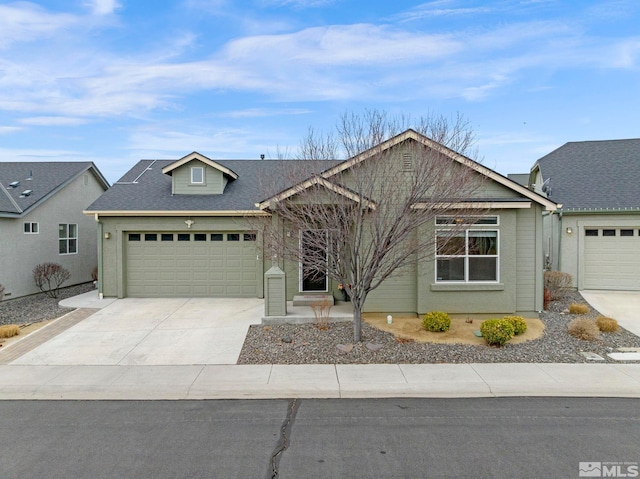 single story home with an attached garage, a shingled roof, and concrete driveway