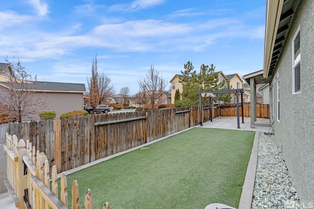 view of yard with a patio area, a fenced backyard, and a residential view